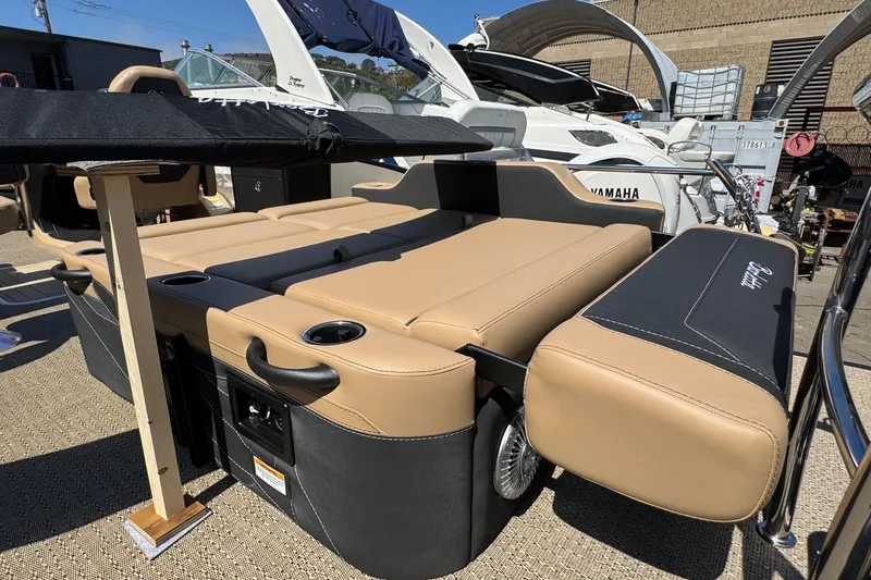 Slide: The Image of 2026 Barletta Cabrio 24UE pontoon boat interior with seating and table, docked outdoors. - 62