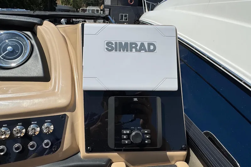 Slide: The Image of Control panel of 2026 Barletta Cabrio 24UE boat with Simrad and JBL systems. - 70