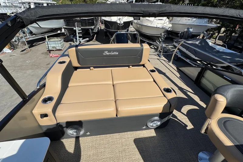 Slide: The Image of 2026 Barletta Cabrio 24UE boat with tan seating and cup holders on deck. - 78