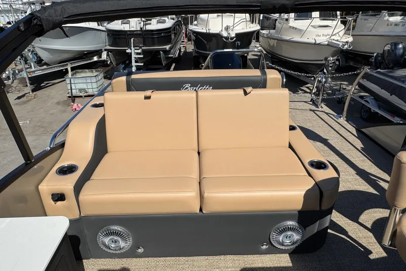 Slide: The Image of 2026 Barletta Cabrio 24UE boat interior with tan seating and cup holders. - 83