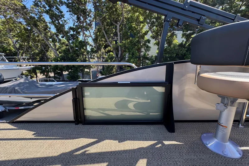 Slide: The Image of 2026 Barletta Cabrio 24UE pontoon boat interior with seating and railing, surrounded by trees. - 88