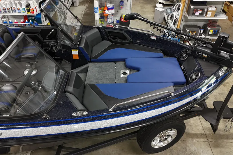 Slide: The Image of 2025 Skeeter Solera 189 boat interior with blue and black seating, in a showroom. - 7