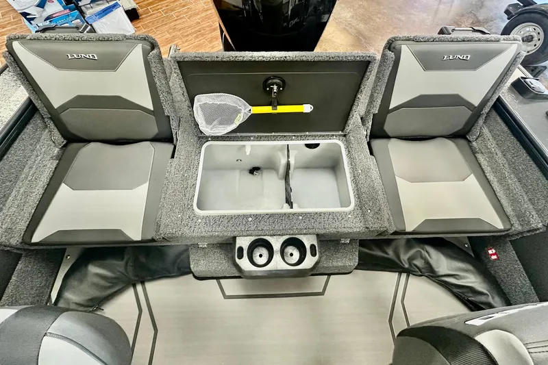 Slide: The Image of 2026 Lund 1875 Crossover XS boat interior with seating and storage compartments. - 13