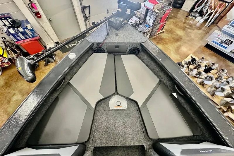 Slide: The Image of 2026 Lund 1875 Crossover XS boat interior with gray seating and fishing equipment. - 18