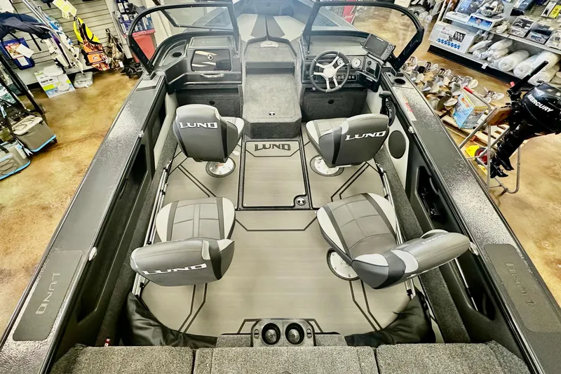 Slide: The Image of 2026 Lund 1875 Crossover XS boat interior with four seats and steering console. - 7