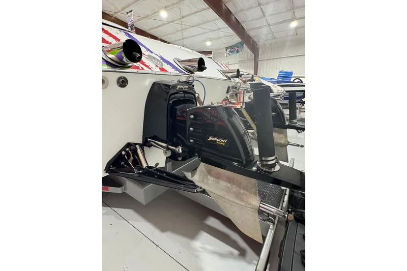 Slide: The Image of 1999 Skater 32B boat with Mercury Racing engines in a garage setting. - 14