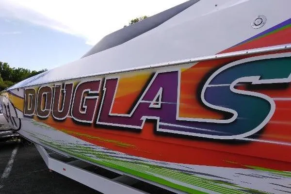 Slide: The Image of Colorful Skater 32B speedboat from 1999 with vibrant "DOUGLAS" graphics. - 19