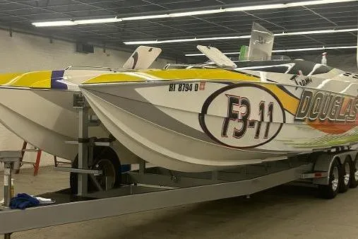 Slide: The Image of 1999 Skater 32B powerboat with vibrant graphics on a trailer in a garage. - 20