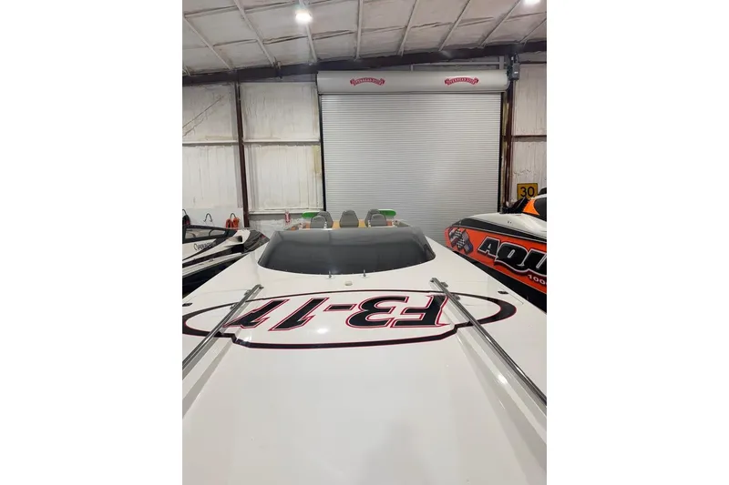 Slide: The Image of 1999 Skater 32B boat in a garage, featuring bold graphics and sleek design. - 3