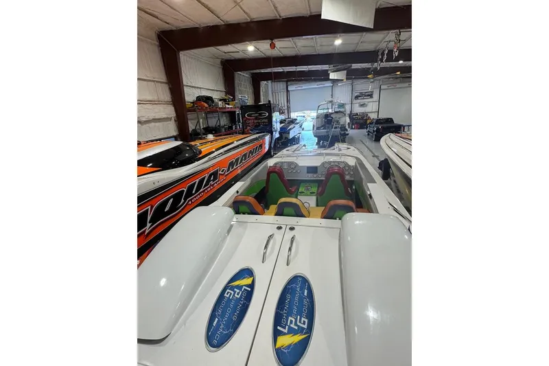 Slide: The Image of 1999 Skater 32B powerboat in a garage with colorful interior and performance branding. - 4