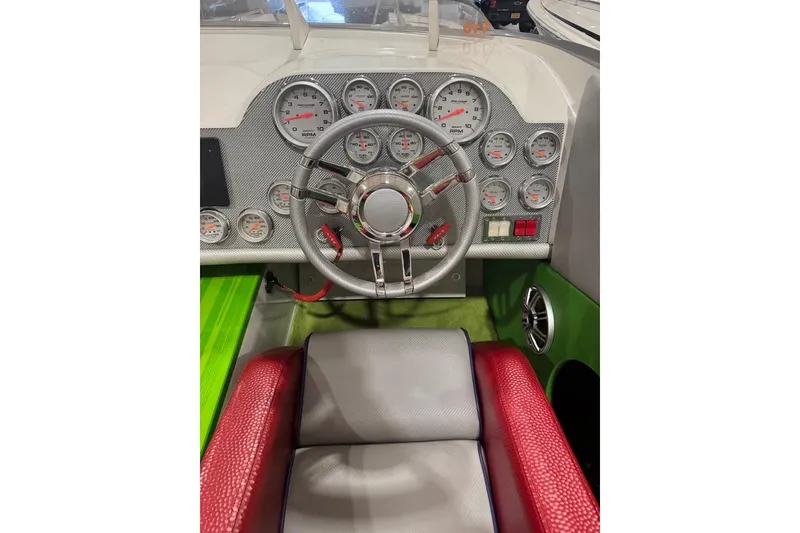 Slide: The Image of 1999 Skater 32B boat dashboard with gauges, steering wheel, and red seating. - 7