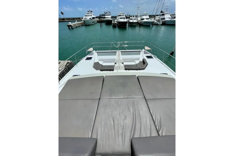 Slide: The Image of 2019 Nautitech 47 Power yacht deck with sun loungers, docked in marina. - 11