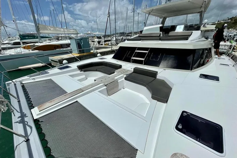 Slide: The Image of 2019 Nautitech 47 Power yacht docked in marina, featuring spacious deck and seating area. - 16