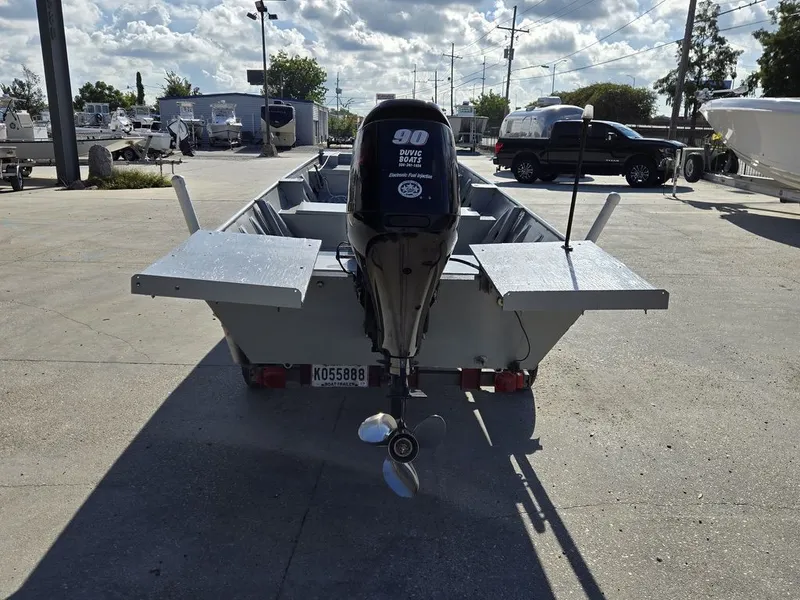 Slide: The Image of 1991 Alumaweld FLATBOAT with outboard motor in a parking lot. - 11