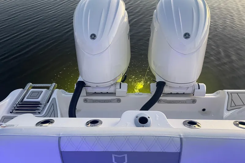 Slide: The Image of 2026 Sea Fox 268 Commander boat interior with dual engines and seating, on sparkling water. - 7