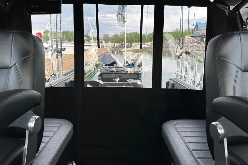Slide: The Image of Interior view of 2023 Extreme Boats 795 Game King, featuring leather seats and fishing rods. - 28