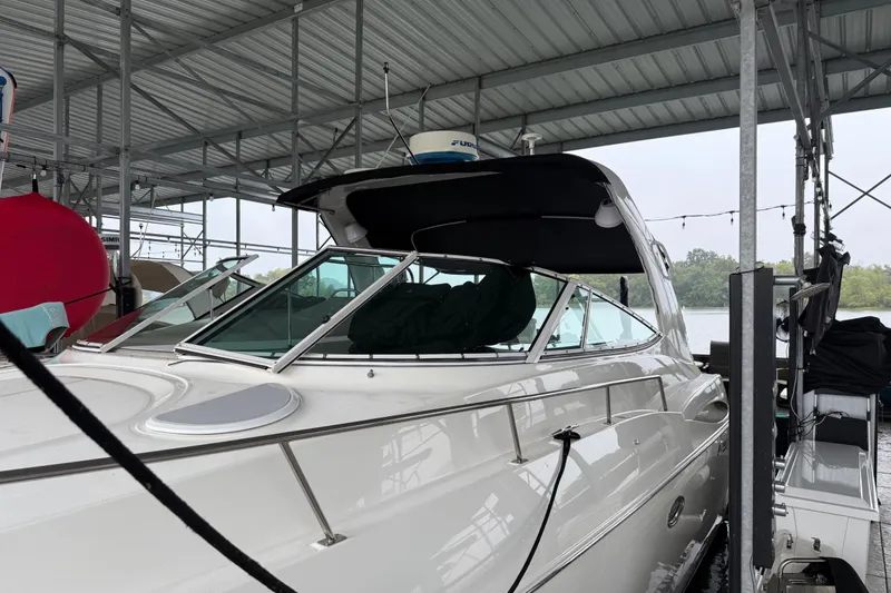 Slide: The Image of 2001 Cruisers Yachts 3672 Express docked under a metal canopy. - 12