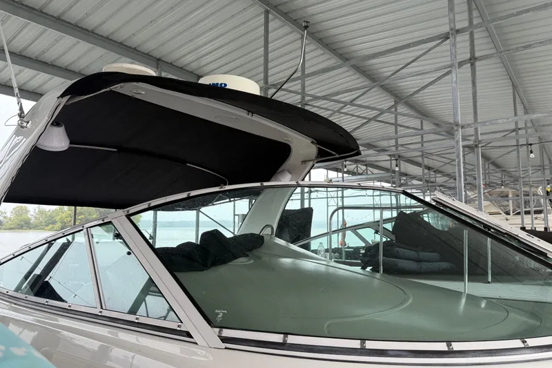 Slide: The Image of 2001 Cruisers Yachts 3672 Express under a metal canopy, showcasing sleek design and tinted windows. - 23