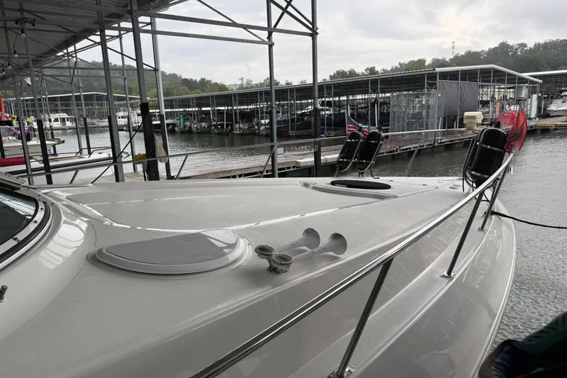 Slide: The Image of 2001 Cruisers Yachts 3672 Express docked at marina under overcast sky. - 24