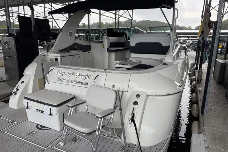 Slide: The Image of 2001 Cruisers Yachts 3672 Express docked, featuring seating and cooler on deck. - 26