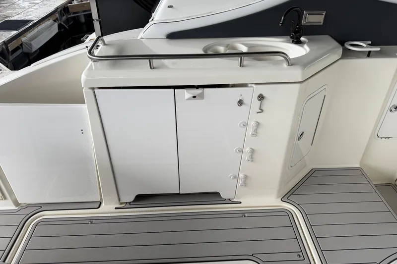 Slide: The Image of 2001 Cruisers Yachts 3672 Express boat deck with sink and storage cabinets. - 30