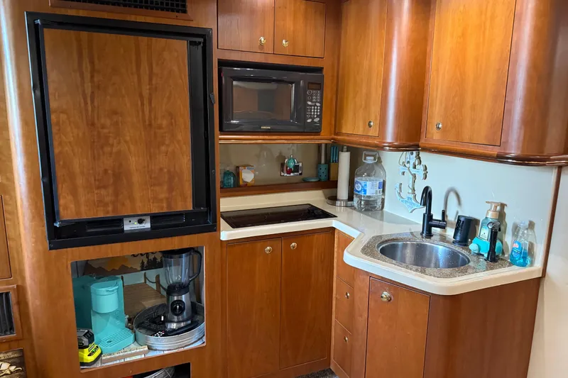 Slide: The Image of 2001 Cruisers Yachts 3672 Express kitchen with wood cabinets, sink, and appliances. - 44