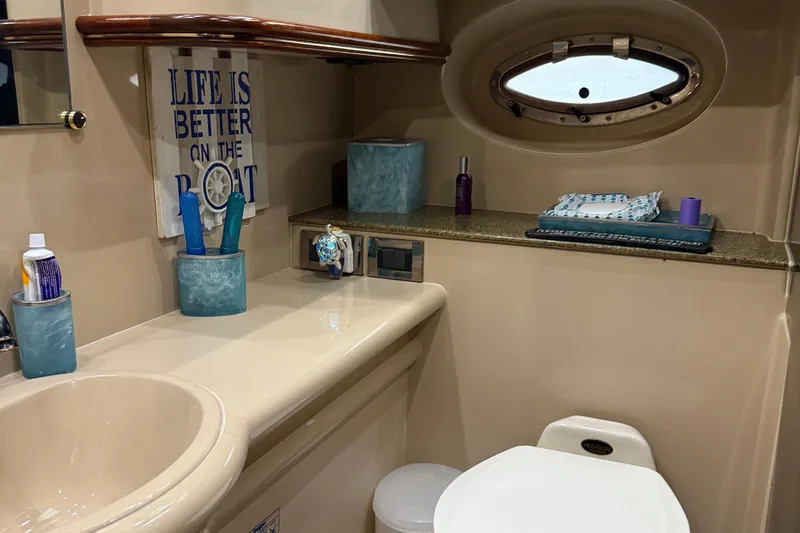 Slide: The Image of 2001 Cruisers Yachts 3672 Express bathroom with porthole, sink, and decorative sign. - 46