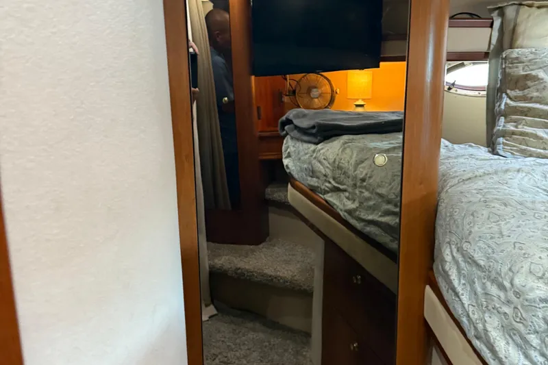 Slide: The Image of Interior of 2001 Cruisers Yachts 3672 Express, featuring cozy bedroom and wooden accents. - 47