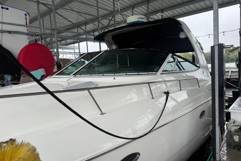 Slide: The Image of 2001 Cruisers Yachts 3672 Express docked under a covered marina. - 5