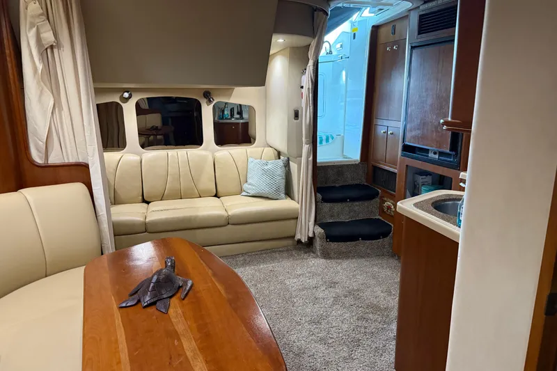 Slide: The Image of Interior of 2001 Cruisers Yachts 3672 Express with beige seating and wooden accents. - 50