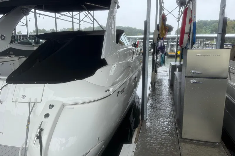 Slide: The Image of 2001 Cruisers Yachts 3672 Express docked under a covered marina with nearby storage. - 9