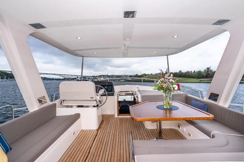 Slide: The Image of Luxurious 2024 Fleming 58 Pilothouse yacht interior with elegant seating and wooden table. - 10