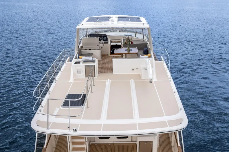 Slide: The Image of 2024 Fleming 58 Pilothouse yacht with spacious deck and seating area on calm water. - 8