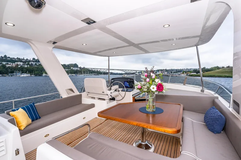 Slide: The Image of Luxurious 2024 Fleming 58 Pilothouse yacht with elegant seating and floral centerpiece. - 9