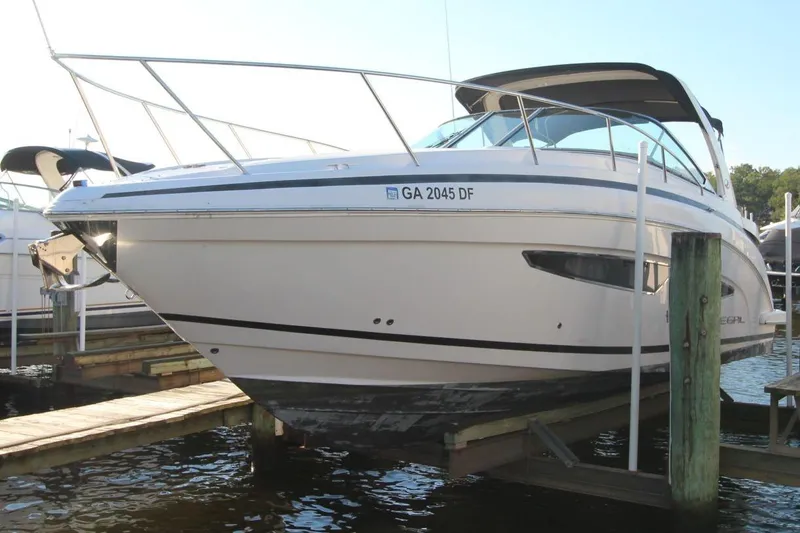The Image of 2015 Regal 32 Express boat docked on a lift, side view. - 0