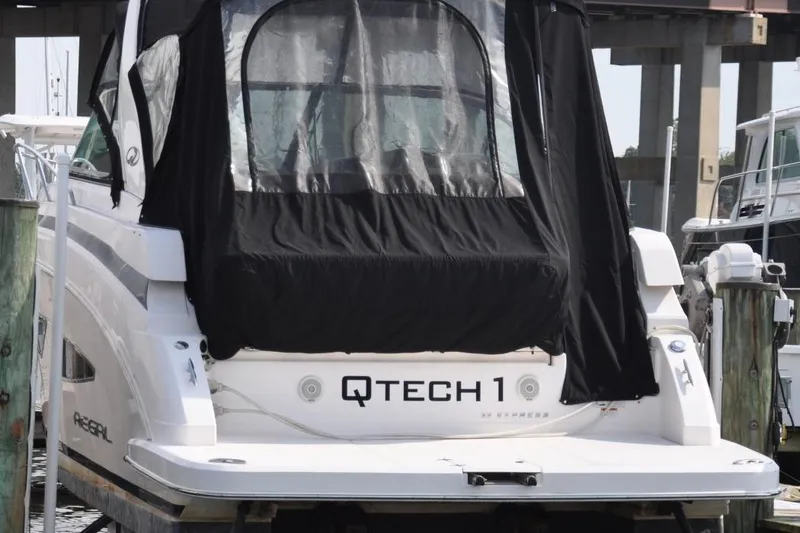 Slide: The Image of 2015 Regal 32 Express boat docked, featuring black canvas cover and visible branding. - 10