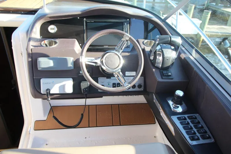 Slide: The Image of 2015 Regal 32 Express helm with steering wheel, controls, and navigation equipment. - 15