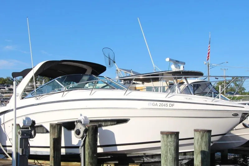 Slide: The Image of 2015 Regal 32 Express boat docked at marina under clear blue sky. - 2
