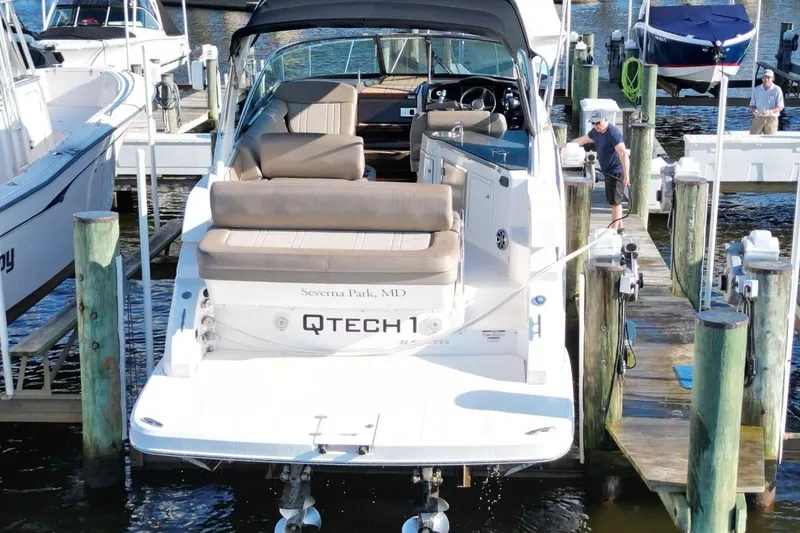 Slide: The Image of 2015 Regal 32 Express boat docked at marina, rear view with seating and canopy. - 3