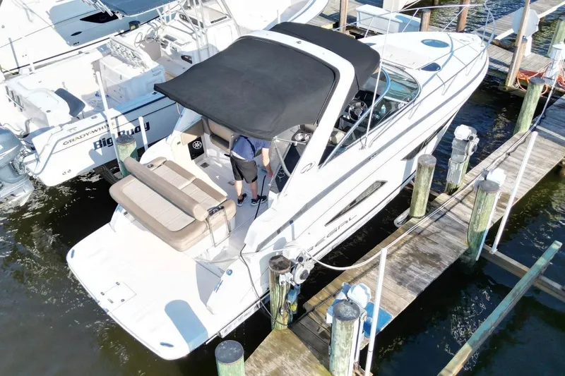 Slide: The Image of 2015 Regal 32 Express boat docked at marina with black canopy. - 8