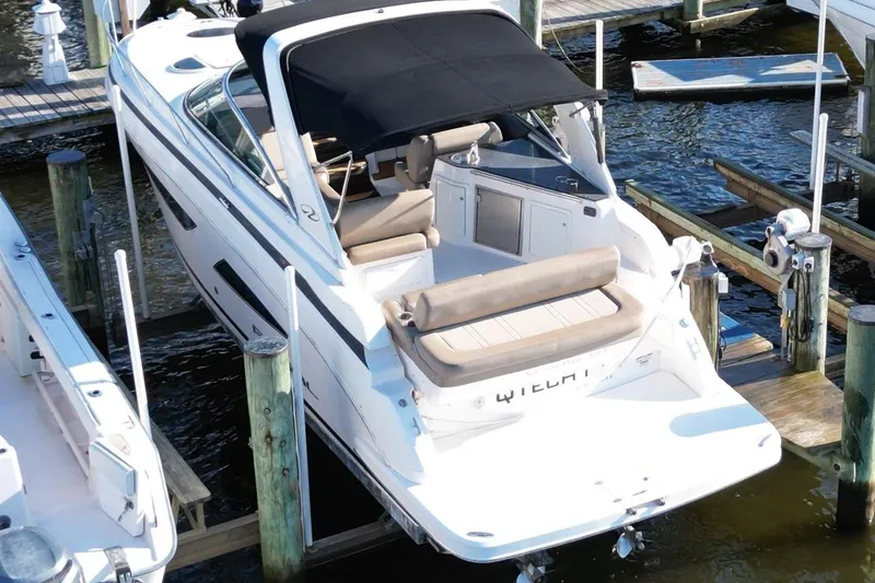 Slide: The Image of 2015 Regal 32 Express boat docked at marina, featuring sleek design and spacious seating. - 9