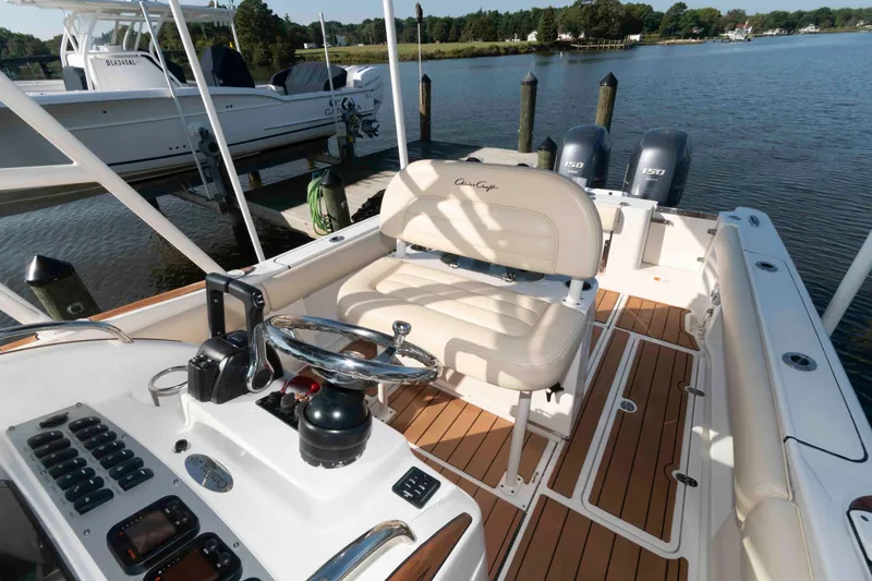 Slide: The Image of 2013 Chris-Craft Catalina 26 boat interior with helm, seating, and twin engines on a calm lake. - 10