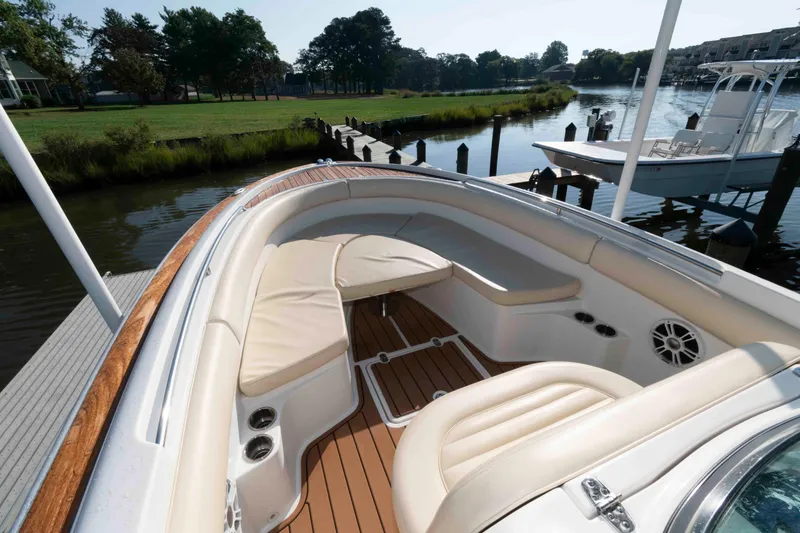 Slide: The Image of 2013 Chris-Craft Catalina 26 boat interior with cushioned seating and wooden deck. - 11