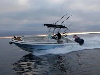 Slide: The Image of 2013 Chris-Craft Catalina 26 boat docked on a lift by a serene waterfront. - 2