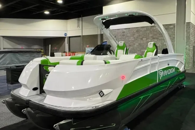 The Image of 2025 Paradigm 25SS pontoon boat with green accents displayed indoors. - 1