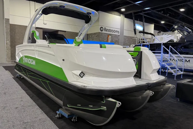 Slide: The Image of 2025 Paradigm 25SS pontoon boat with green accents displayed indoors. - 11