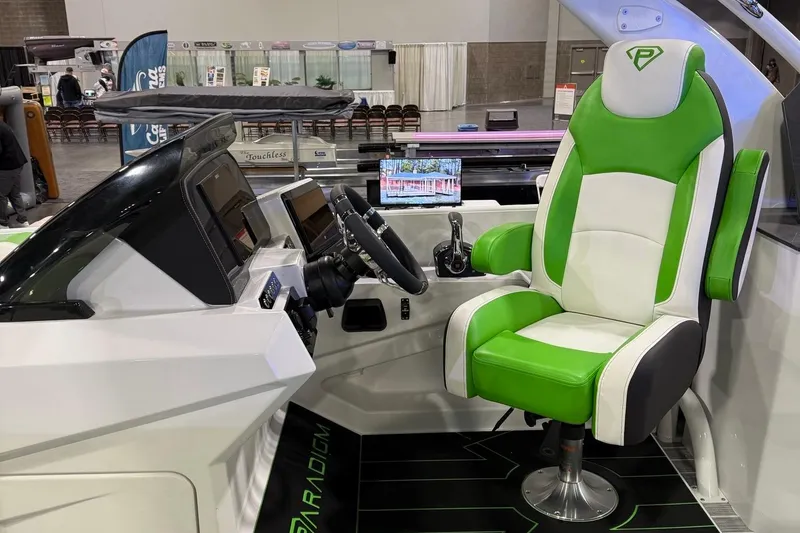 Slide: The Image of 2025 Paradigm 25SS boat interior with green and white captain's chair and modern dashboard. - 14