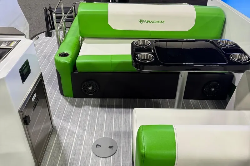 Slide: The Image of 2025 Paradigm 25SS boat interior with green seating, table, and modern amenities. - 16