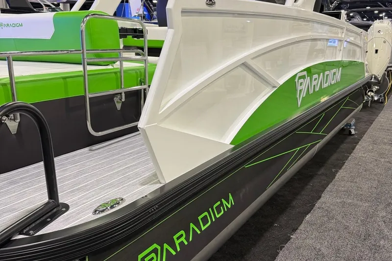 Slide: The Image of 2025 Paradigm 25SS boat with green accents on display at a showroom. - 20