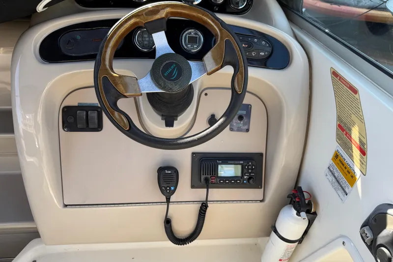 Slide: The Image of Steering console of a 2001 Sea Ray 260 Sundancer boat with controls and radio. - 10